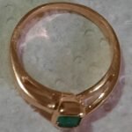 Anillo dorado con piedra verde de bisutería para mujer.