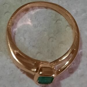 Anillo dorado con piedra verde de bisutería para mujer.